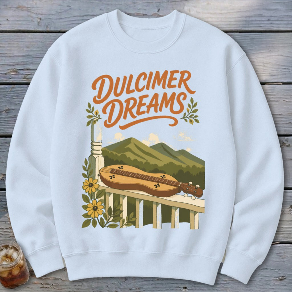Dulcimer Dreams graphic on a light blue sweatshirt with mountains and instrument illustration.