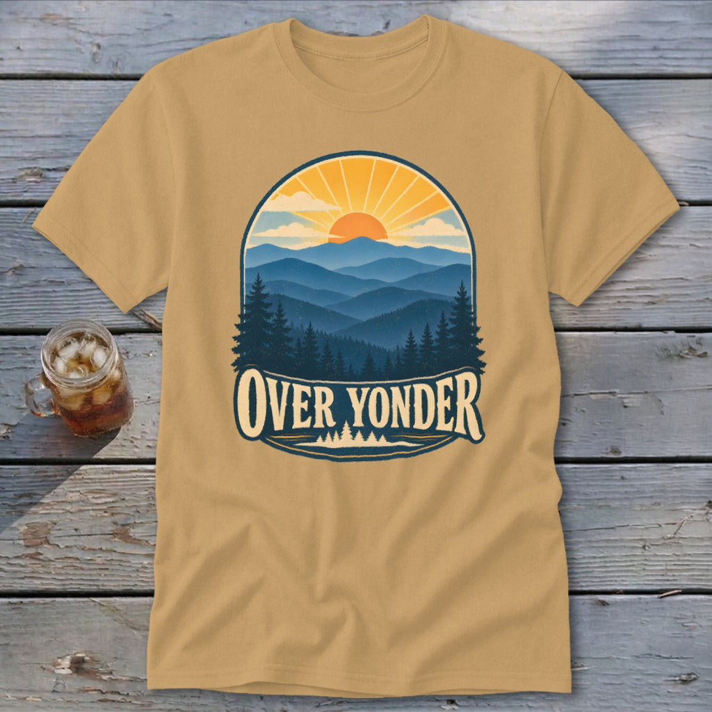 Tan t-shirt featuring a mountain sunset graphic with the text Over Yonder on a wooden background.