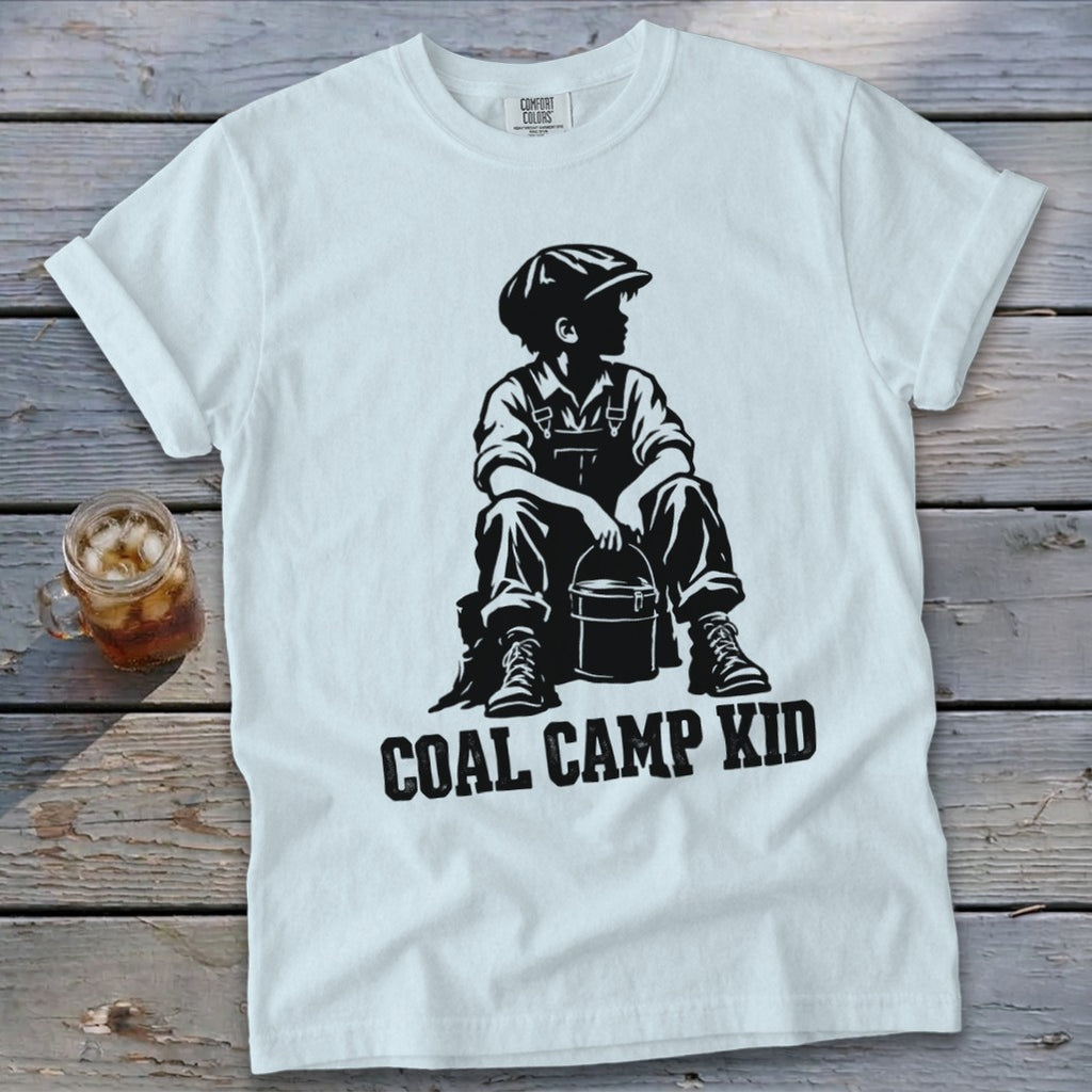 White t-shirt with black graphic of a boy sitting with a bucket and "COAL CAMP KID" text.