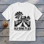 White t-shirt with black graphic of a farmhouse, trees, fence, and text "OLD HOME PLACE".