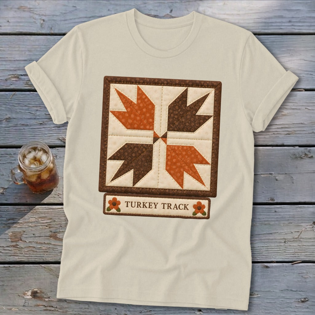 Cream t-shirt with a "Turkey Track" quilt block design.