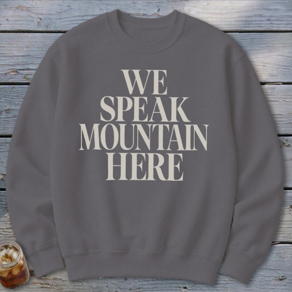 Grey sweatshirt with "We Speak Mountain Here" printed in cream text.