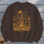 Brown sweatshirt with orange mountain landscape and text "If you hear whistlin', keep hiking."