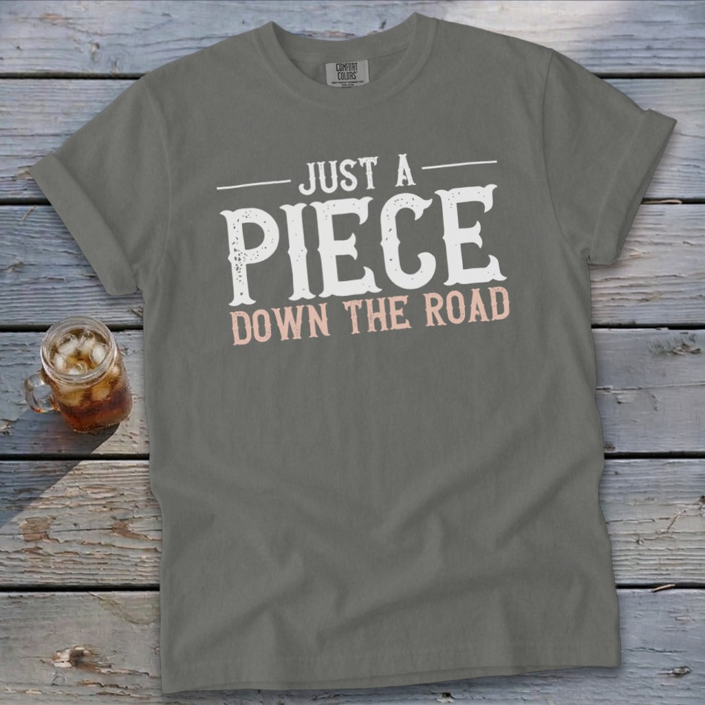 Gray t-shirt with "JUST A PIECE DOWN THE ROAD" text graphic.