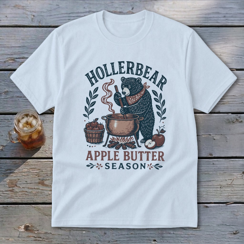 White t-shirt featuring a bear stirring apple butter, with text "HOLLERBEAR" and "APPLE BUTTER SEASON".