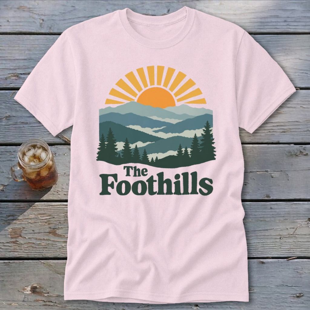Pink t-shirt with mountain landscape graphic and "The Foothills" text.