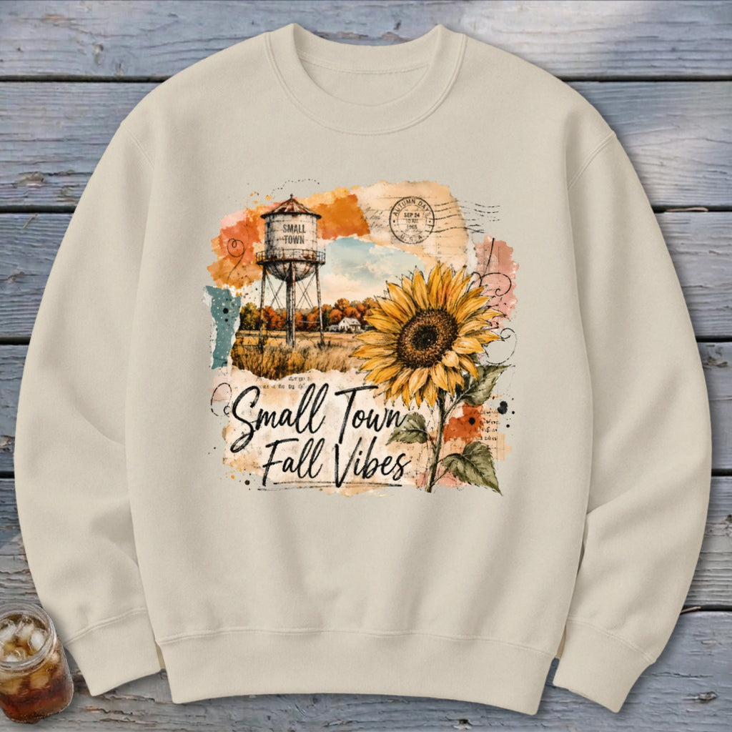 Crewneck sweatshirt with "Small Town Fall Vibes" graphic featuring sunflower and water tower.