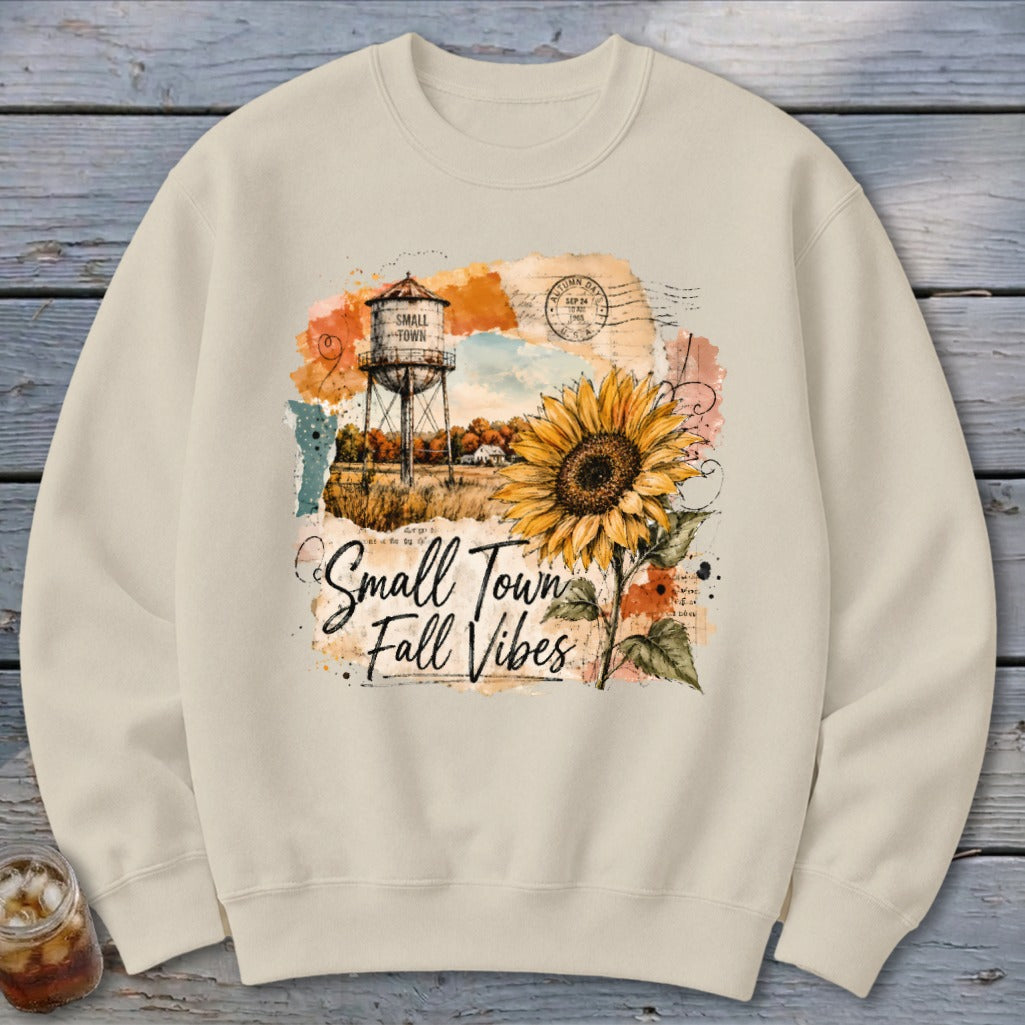 Crewneck sweatshirt with "Small Town Fall Vibes" graphic featuring sunflower and water tower.