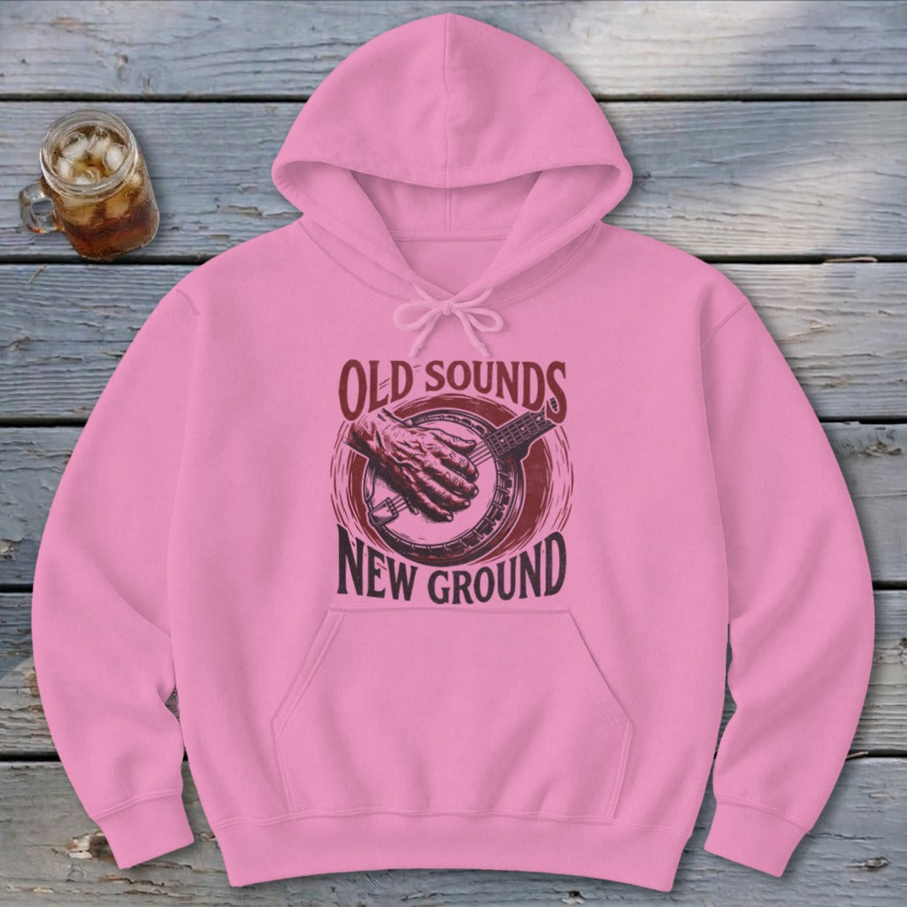 Pink hooded sweatshirt with a distressed banjo graphic and the text Old Sounds New Ground.