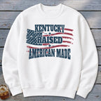 White sweatshirt with "Kentucky Raised American Made" text and distressed American flag graphic.