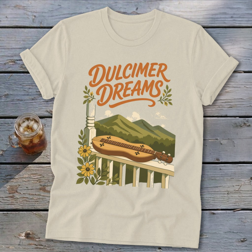 Cream t-shirt with "Dulcimer Dreams" text, dulcimer, mountains, and flowers graphic.
