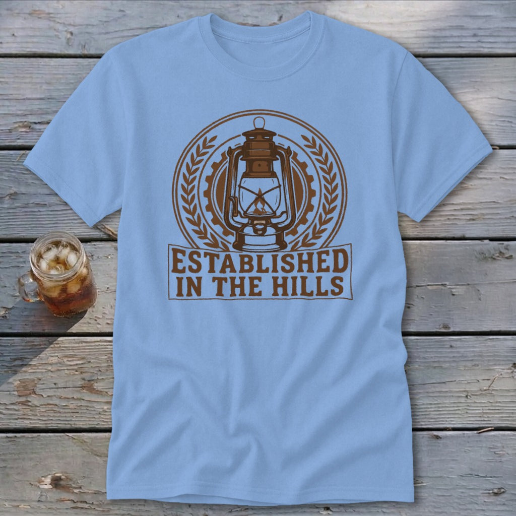 Light blue t-shirt with a brown lantern graphic and text "ESTABLISHED IN THE HILLS".