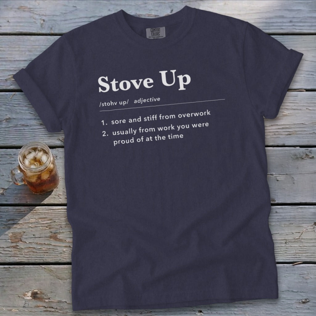 Dark blue t-shirt featuring the definition of "Stove Up" printed in white on a rustic wooden background.