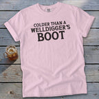 Pink t-shirt with black text reading "COLDER THAN A WELLDIGGER'S BOOT".
