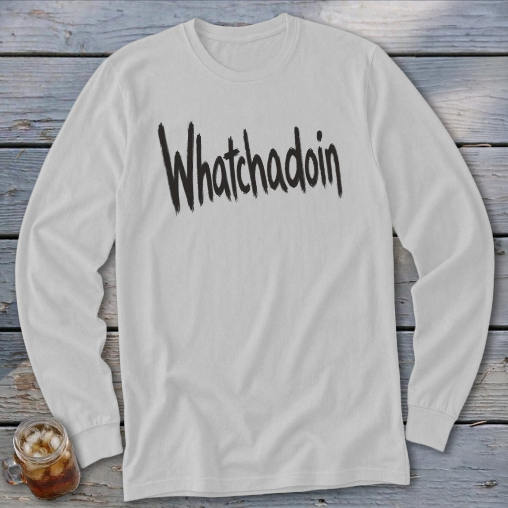 White long sleeve shirt with black "Whatchadoin" text and a glass of iced drink.