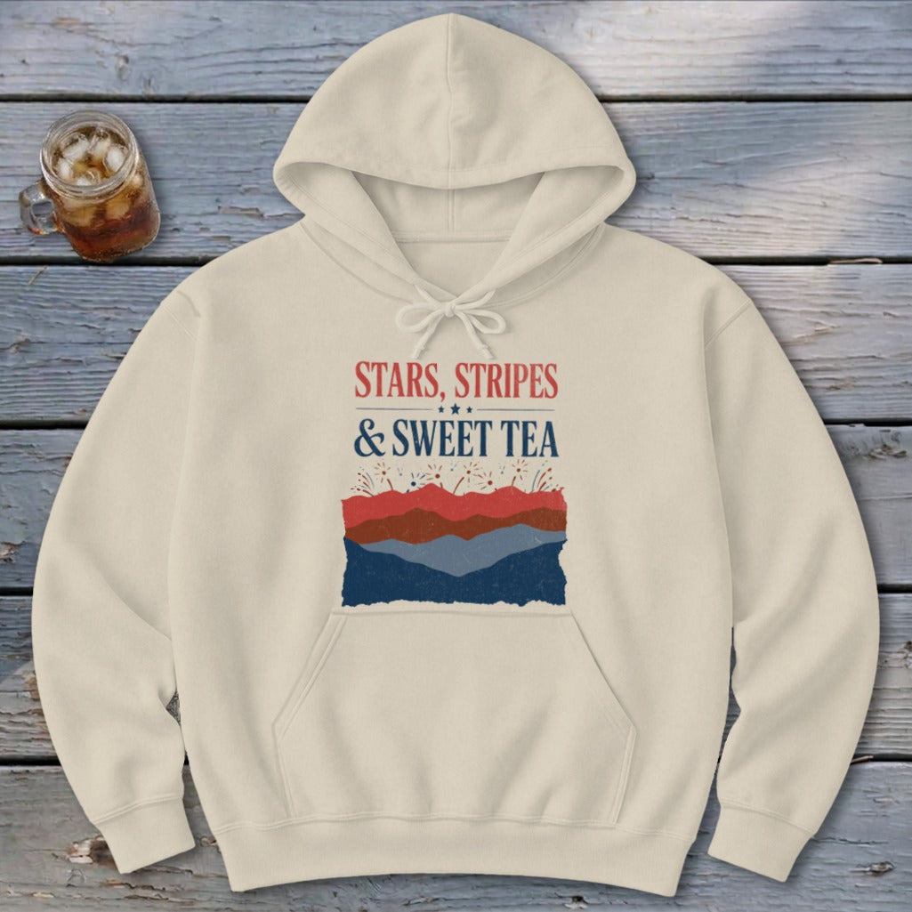Cream-colored hooded sweatshirt featuring the red, white, and blue text "Stars, Stripes & Sweet Tea" and abstract landscape graphic.