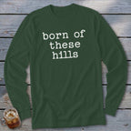 Long sleeve dark green shirt with white text that reads "born of these hills."