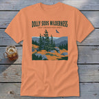 An orange t-shirt featuring a green graphic of the Dolly Sods Wilderness with pine trees and a soaring bird.