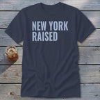 Navy t-shirt with "NEW YORK RAISED" printed in light blue.