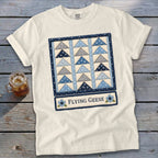 White t-shirt with a quilt block design featuring blue and grey triangles and text "Flying Geese".
