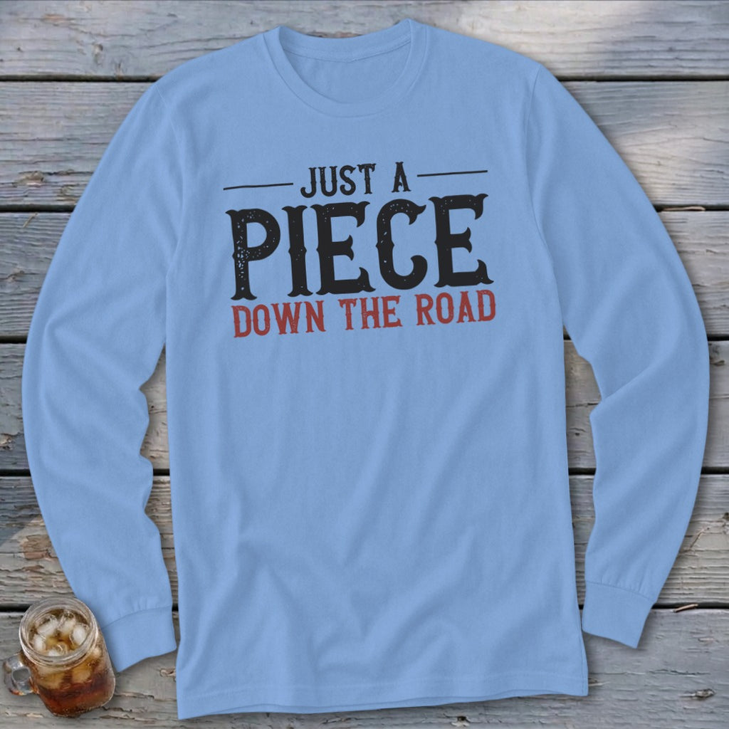 Light blue long-sleeve shirt with "JUST A PIECE DOWN THE ROAD" graphic.