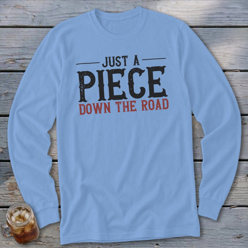 Light blue long-sleeve shirt with "JUST A PIECE DOWN THE ROAD" graphic.