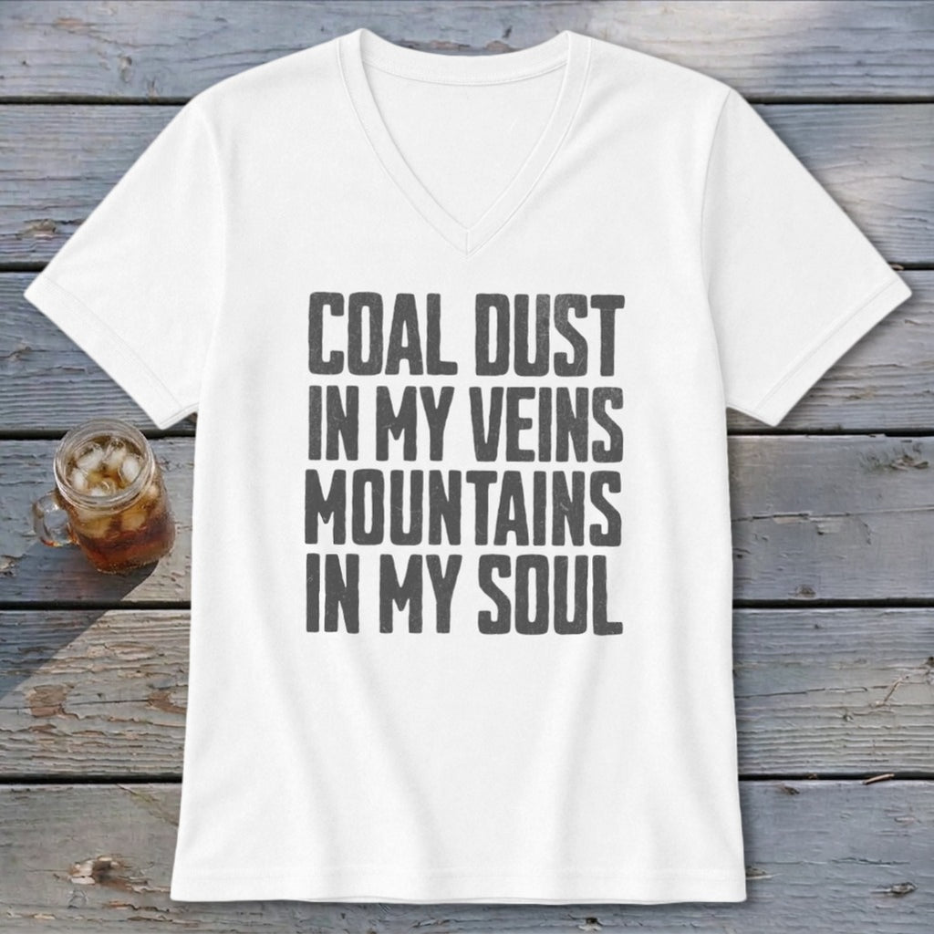 A white V-neck t-shirt with the text "Coal dust in my veins, mountains in my soul" printed in black.