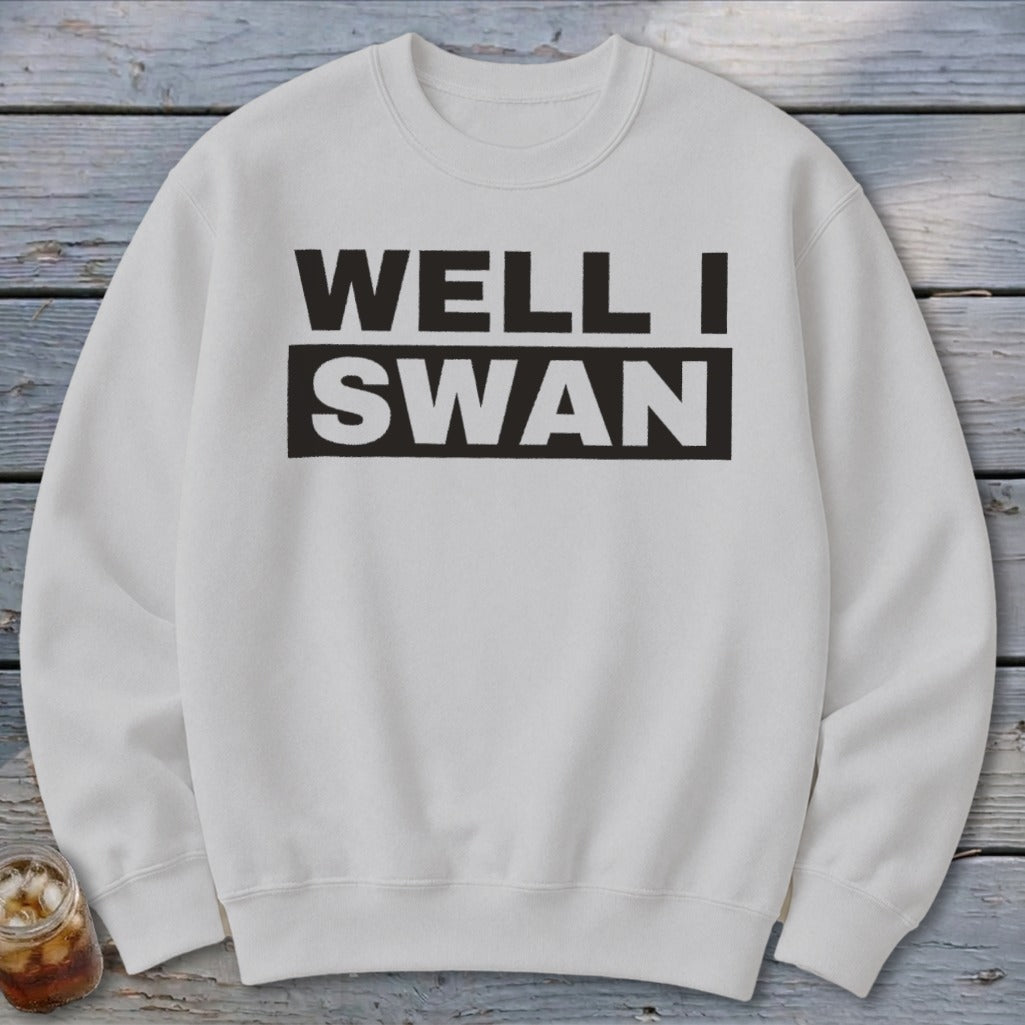 Off-white crewneck sweatshirt featuring the black text WELL I SWAN printed on the chest.