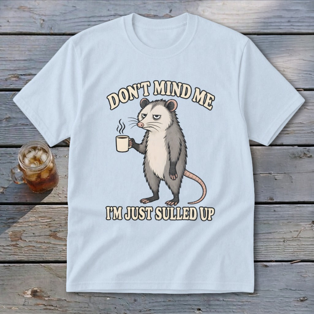 Light blue t-shirt with a grumpy possum holding coffee, text "DON'T MIND ME I'M JUST SULLED UP".