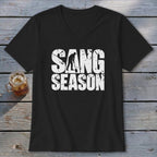 A black V-neck t-shirt with white text reading SANG SEASON and a silhouette digging.
