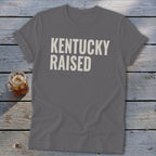 Gray t-shirt with "KENTUCKY RAISED" text in a casual, bold font.