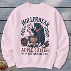 Pink sweatshirt with a bear making apple butter, text reads "Hollerbear Apple Butter Season".