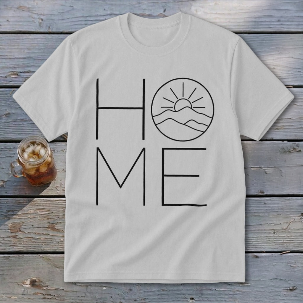 A light gray t-shirt featuring the word HOME in black line art, with a mountain and sun graphic replacing the letter O.