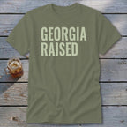 Olive green t-shirt with "GEORGIA RAISED" text in light green.