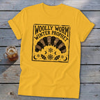 Yellow crewneck t-shirt featuring a black block-print graphic of a woolly worm with snowflakes, leaves, and text reading Woolly Worm Winter Prophet.