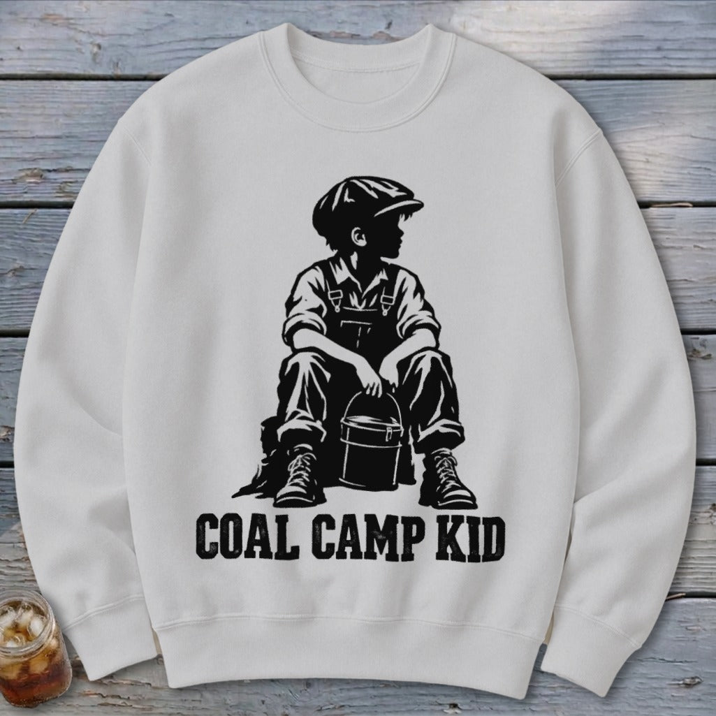 White sweatshirt with black graphic of a boy in overalls and cap holding a bucket, text "COAL CAMP KID".