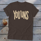 Brown t-shirt with "YOU'UNS" text in cream-colored font.