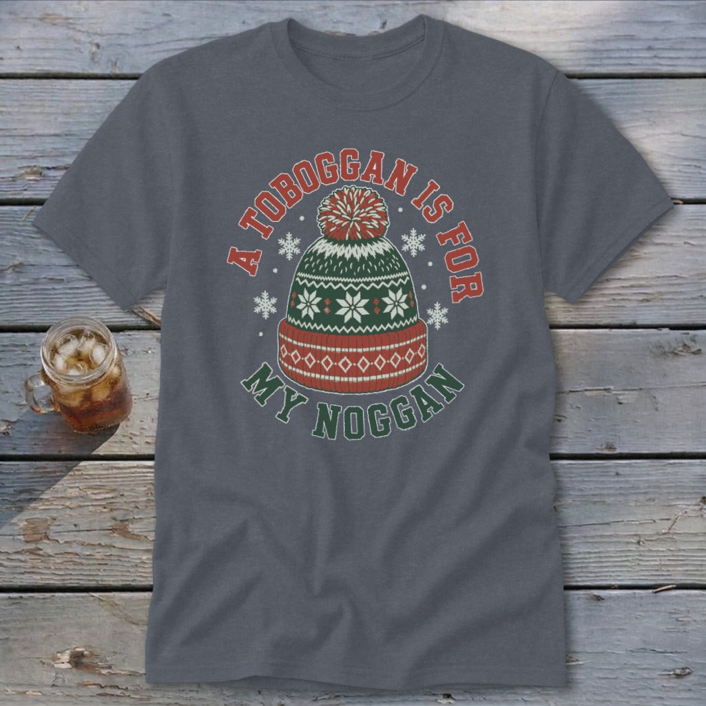 Charcoal gray t-shirt featuring a green, red, and white winter hat graphic and the text A TOBOGGAN IS FOR MY NOGGAN.