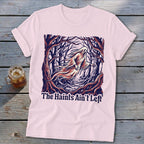 Pink t-shirt with a ghost in a forest graphic and text "The Haints Ain't Left".