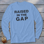 Light blue long sleeve shirt with black text "RAISED IN THE GAP".