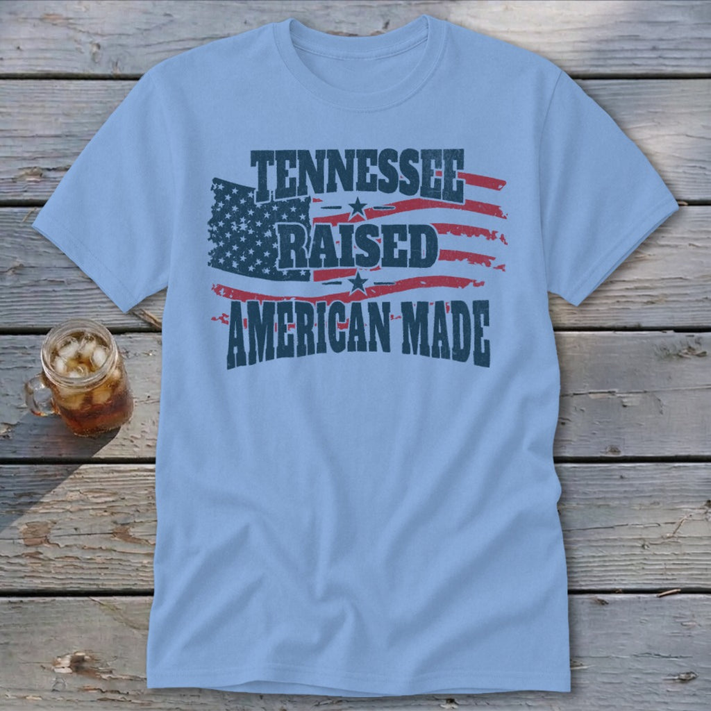 Light blue t-shirt with distressed American flag design and text: Tennessee Raised American Made.