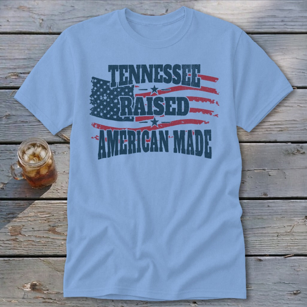 Light blue t-shirt with distressed American flag design and text: Tennessee Raised American Made.