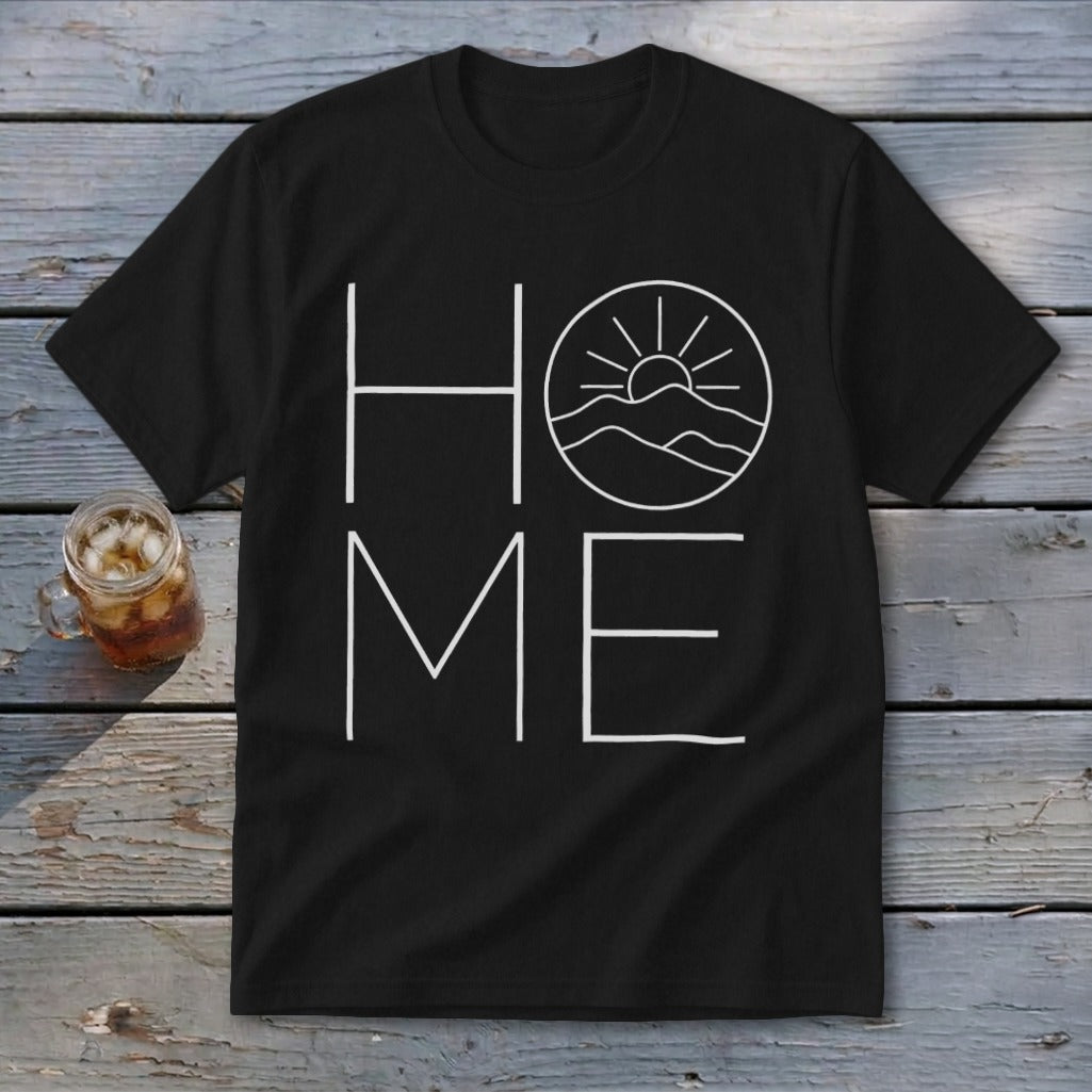 Black t-shirt featuring a white graphic with the word HOME, where the letter O is replaced by a sun setting over mountains.