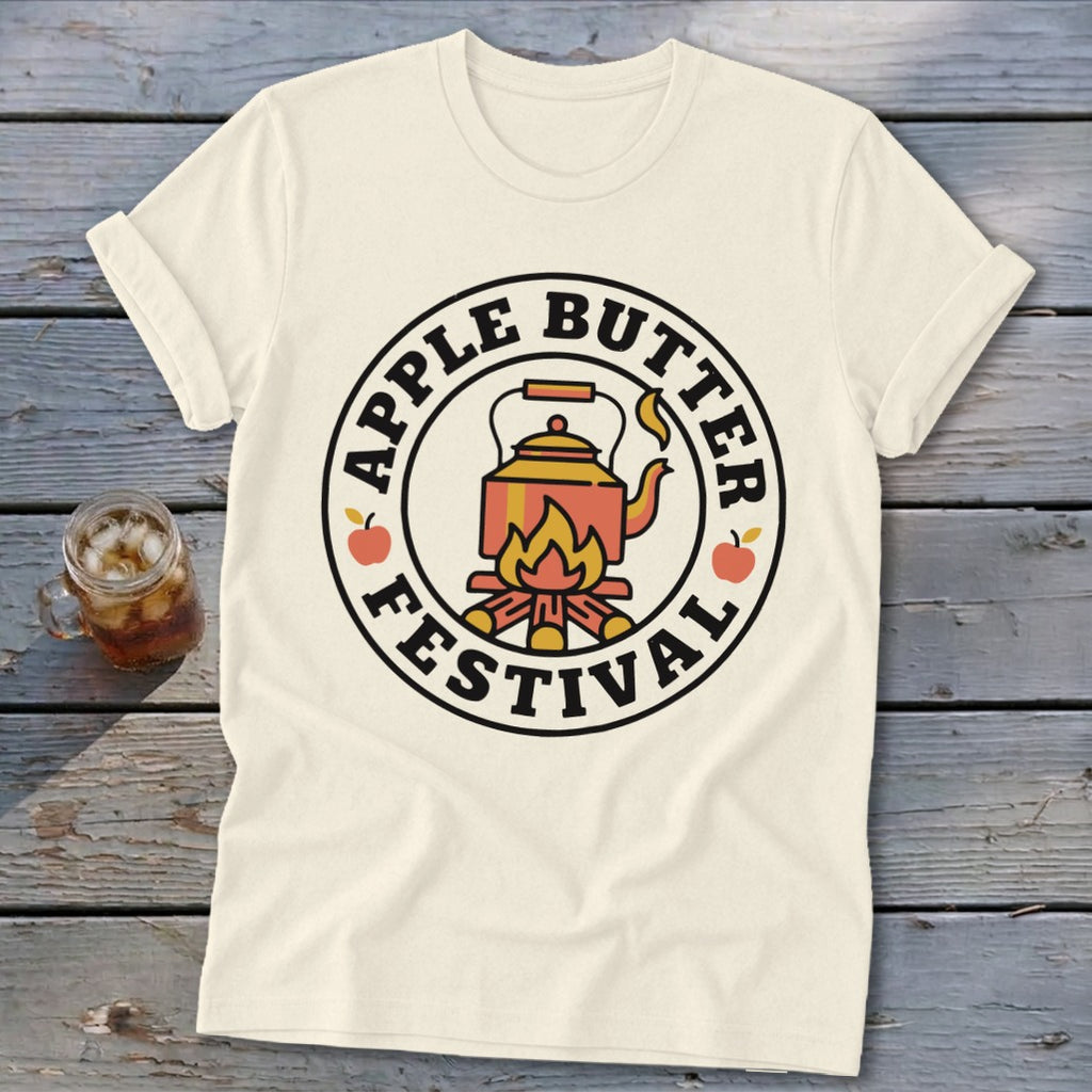 Cream t-shirt with circular Apple Butter Festival graphic featuring a kettle over a fire.