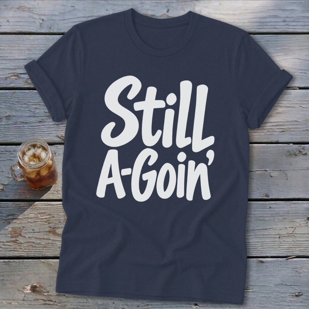 A navy blue crewneck t-shirt featuring the white text Still A-Goin centered on the chest.
