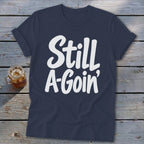 A navy blue crewneck t-shirt featuring the white text Still A-Goin centered on the chest.