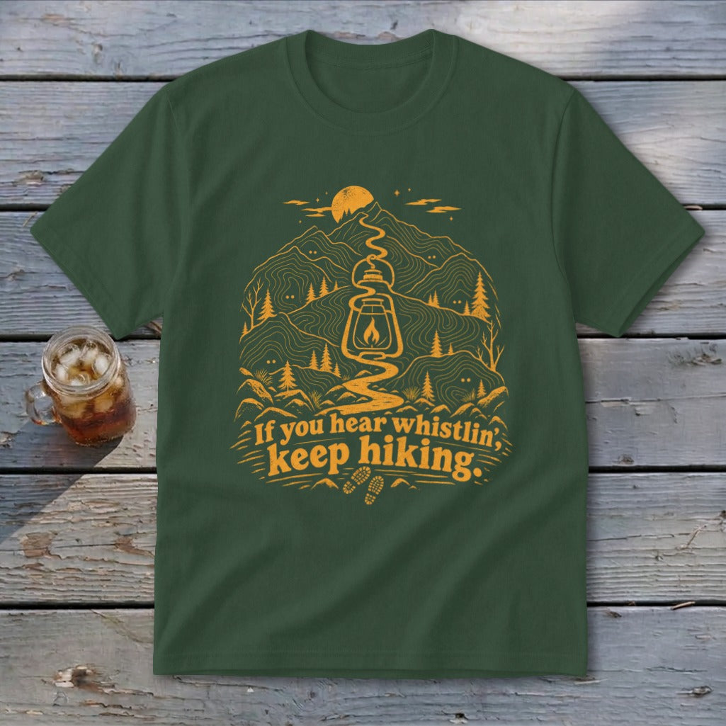 Green t-shirt with orange hiking graphic and text: "If you hear whistlin', keep hiking."