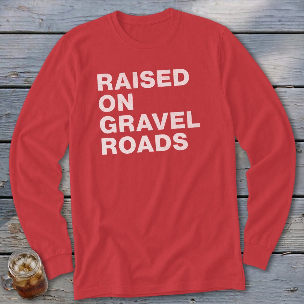 Red long sleeve shirt with "RAISED ON GRAVEL ROADS" in white text.