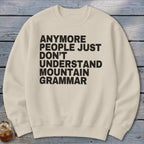 Cream sweatshirt with black text that reads "Anymore people just don't understand mountain grammar."