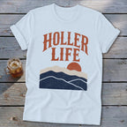 A white t-shirt with the text HOLLER LIFE and a sunset mountain graphic.